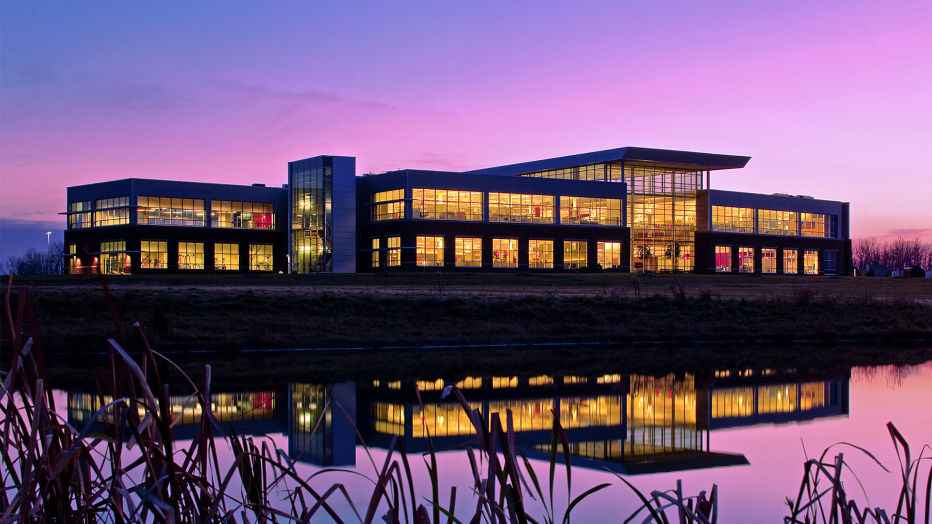 exterior photo of the centurion corporate headquarters across the pond at dusk with pink skies