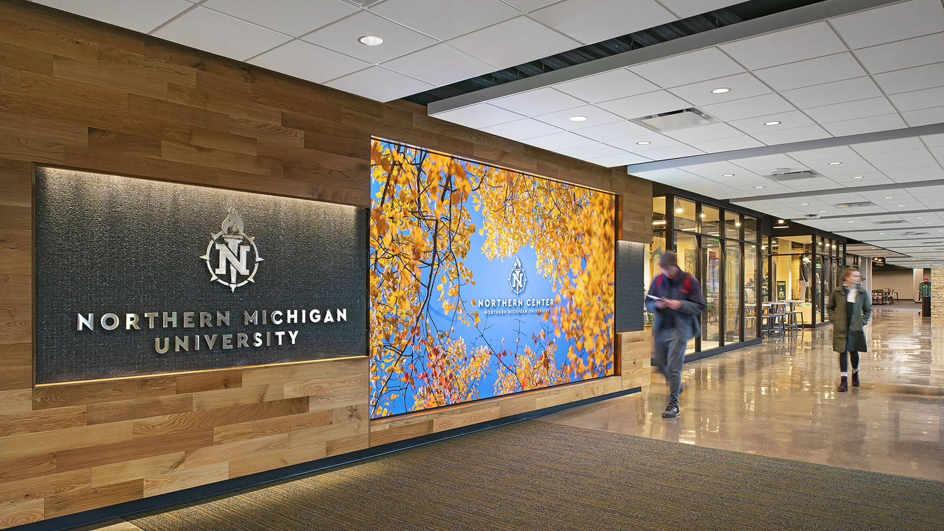 welcome sign at northern michigan university northern center with wooden accent wall and digital screen